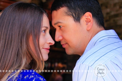 Connie Hanks Photography // ClickyChickCreates.com // engagement couple session, Rosarito, Mexico, mercado, market, colorful, blue, gray, wood, wheel, rustic, arches, archways, kiss